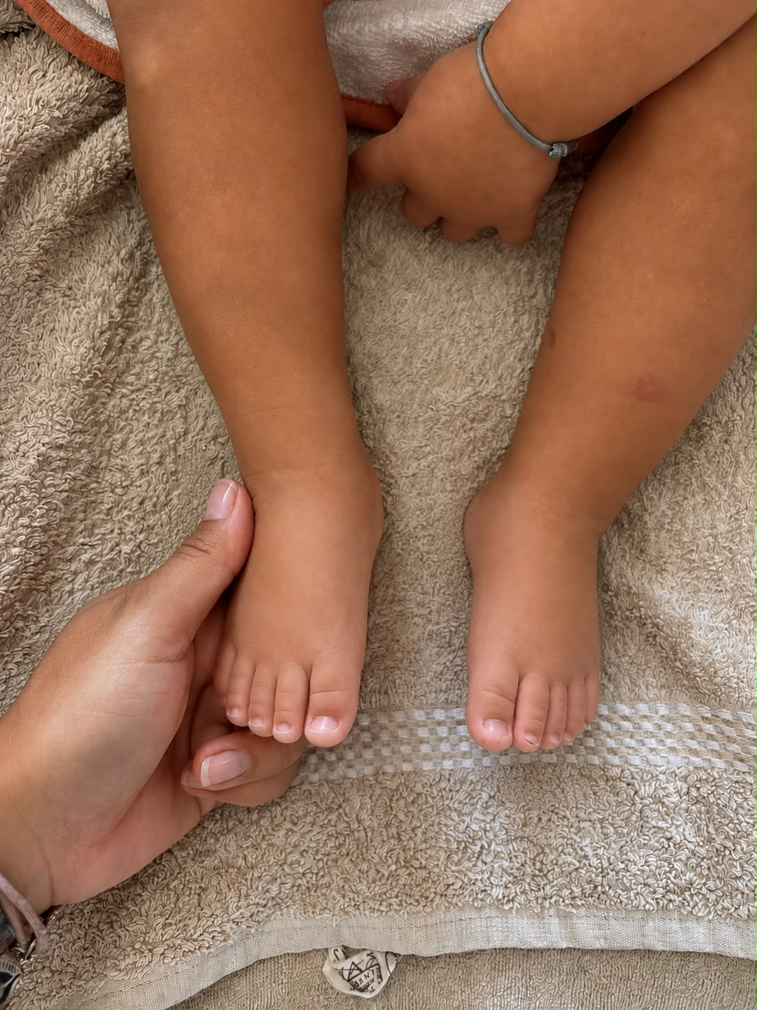 Un adulte masse doucement le pied d’un bébé